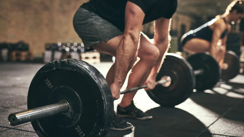 Person lifting weights in a gym to improve strength and conditioning